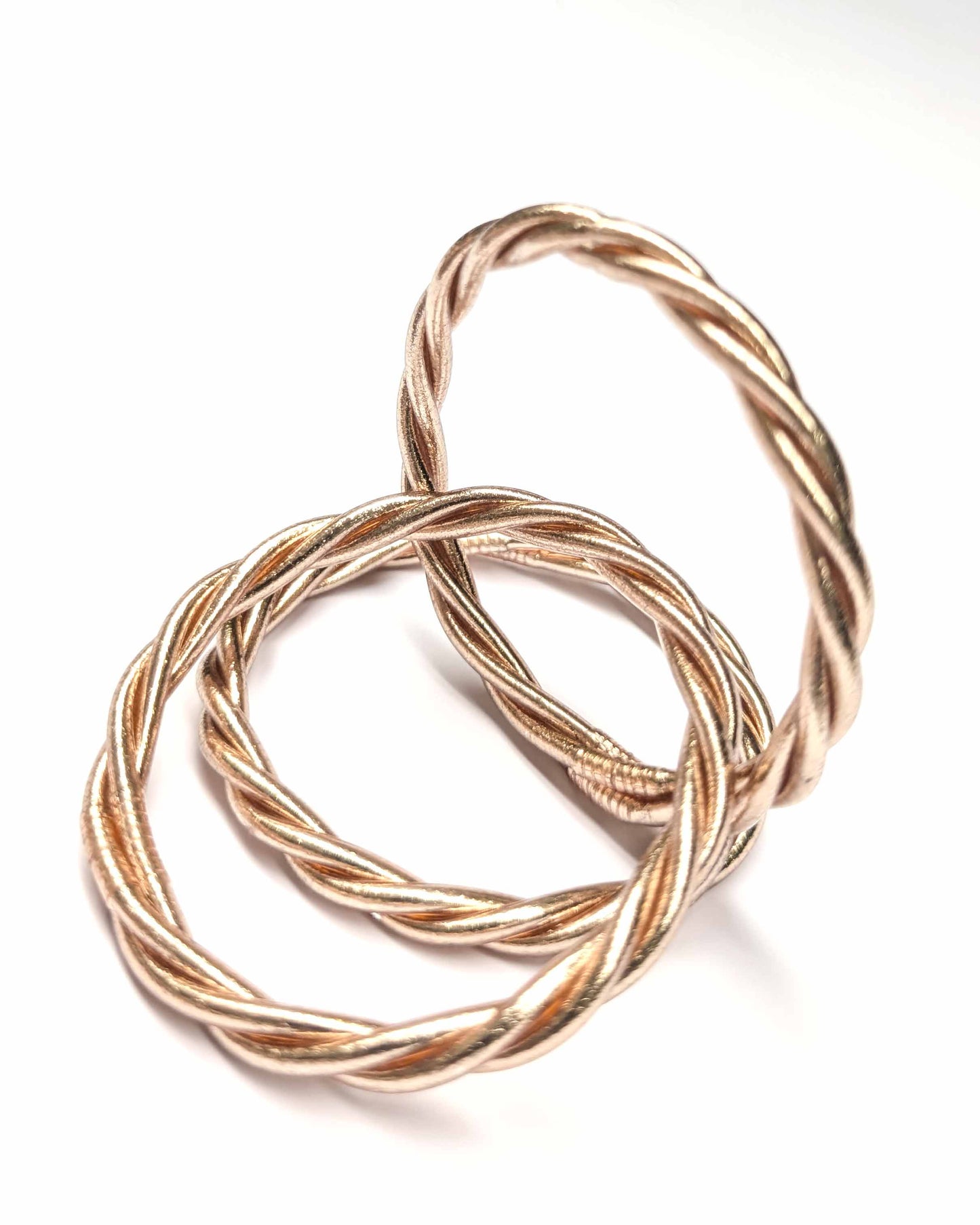 Trinity Kumlai Buddhist bangles in champagne gold, on a neutral background.