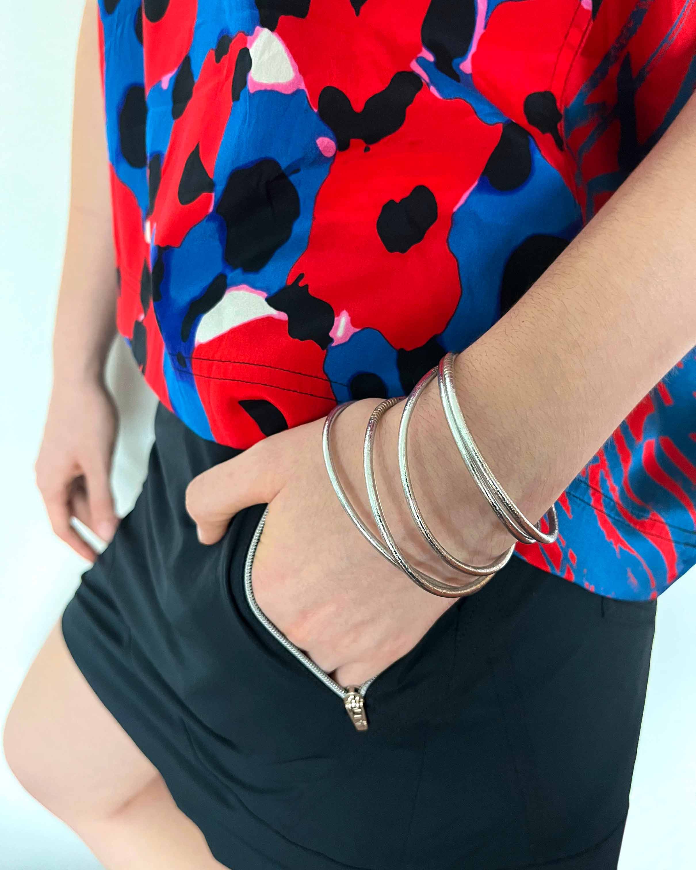Pulseras budistas Kumlai en plata clásica, estilo fino, usadas con un top colorido. (1)