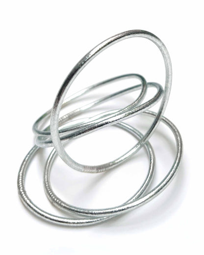Thin Kumlai Buddhist bangles in Classic Silver on a white background.