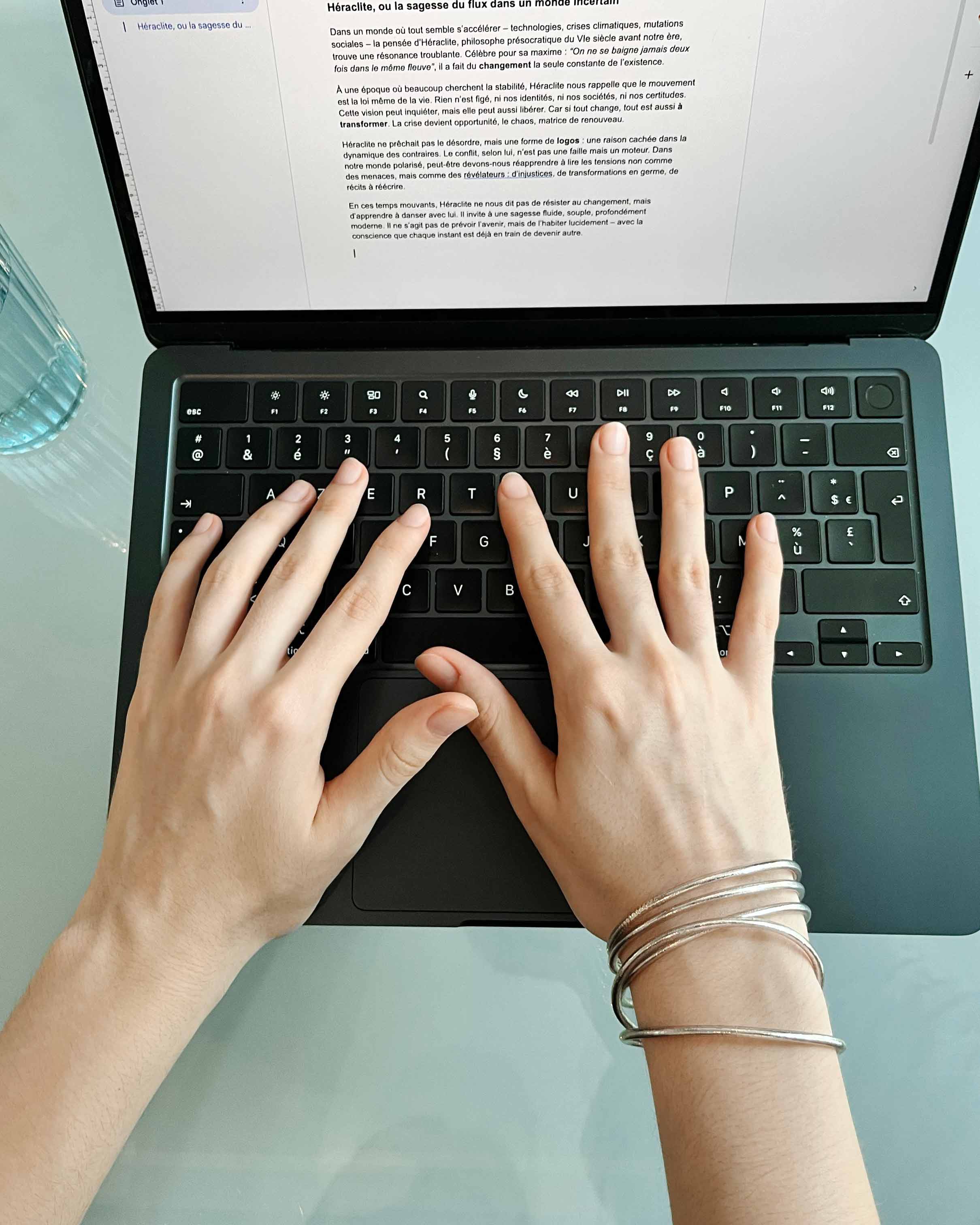 Kumlai Buddhist bangles in rose silver, slim style, worn while using a laptop.