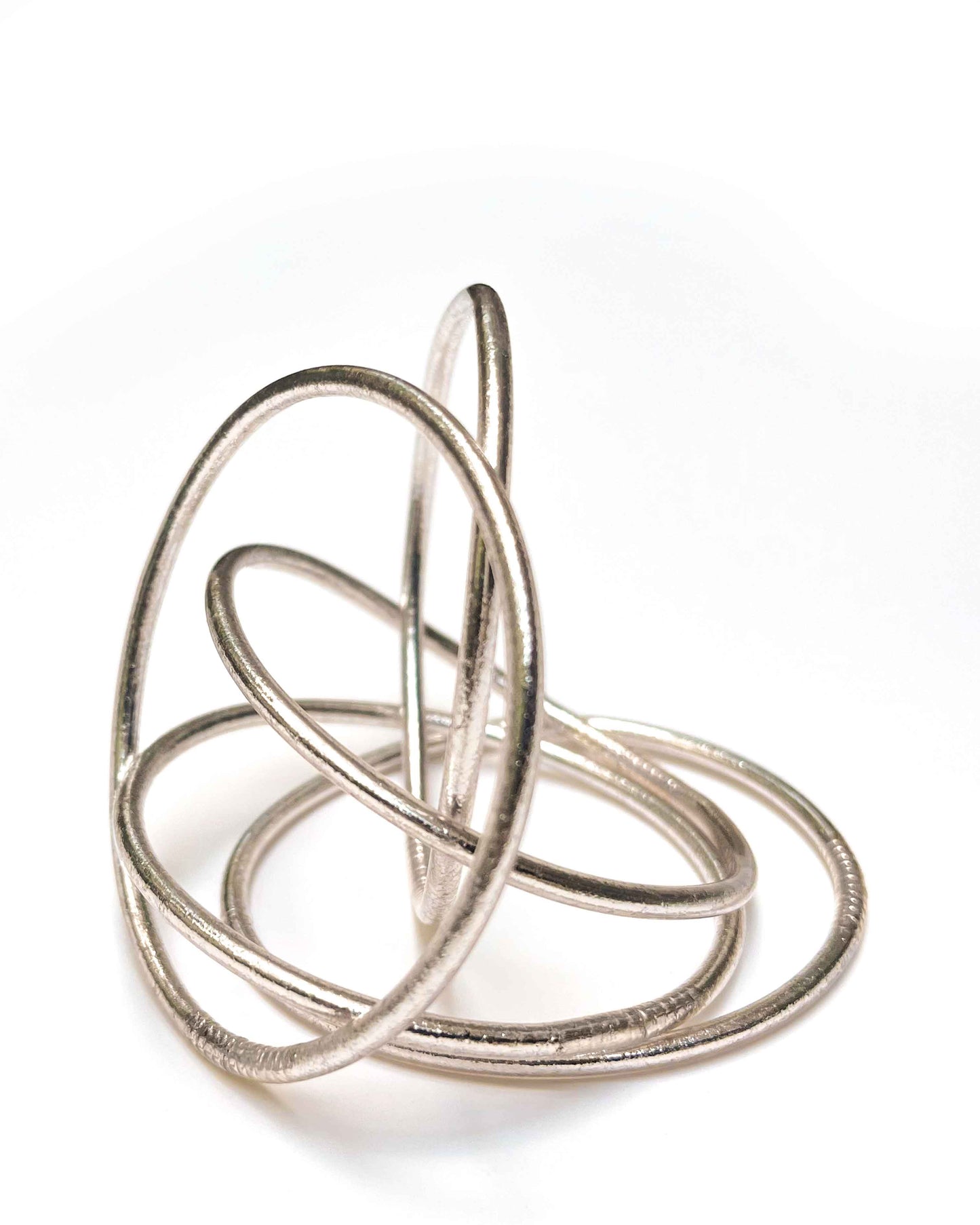 Thin Kumlai Buddhist bangles in Rose Silver on a white background.