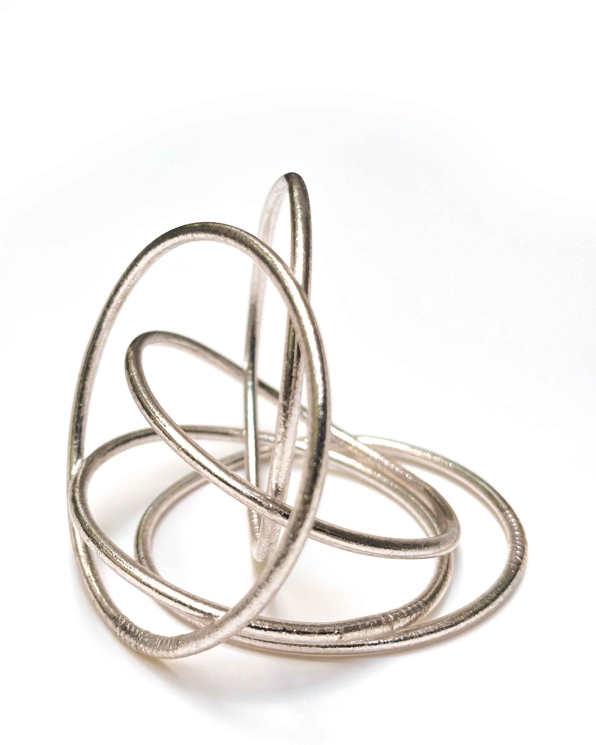 Thin Kumlai Buddhist bangles in Rose Silver on a white background.