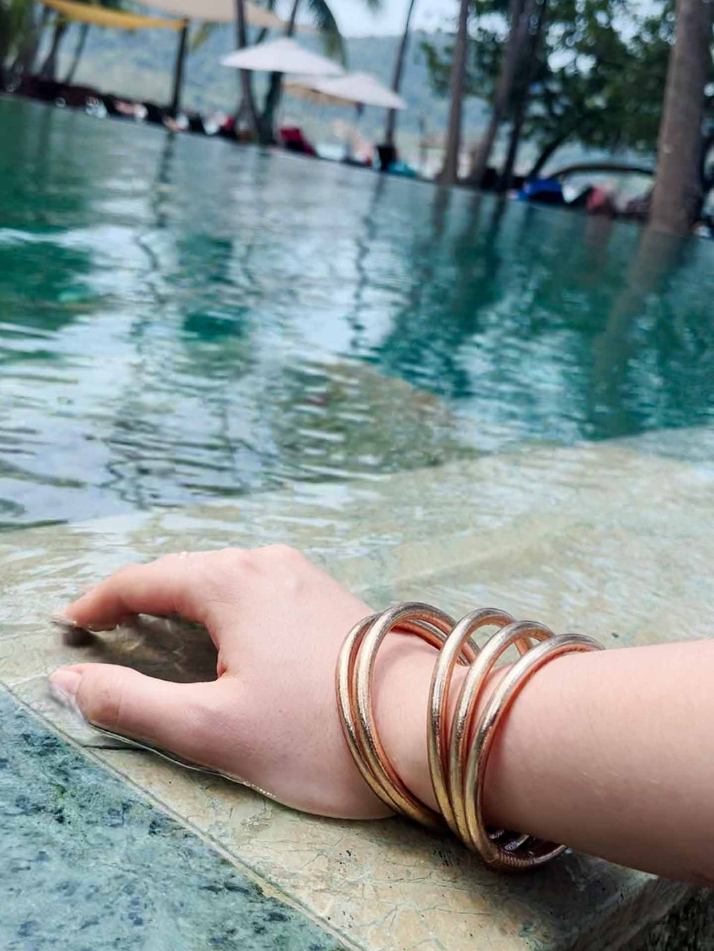 Kumlai Buddhist bangles in champagne gold, chunky style, worn at the swimming pool.