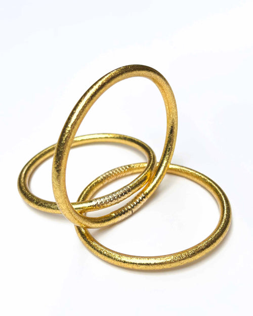 Kumlai Buddhist bangles in classic gold, chunky style, on a white background.