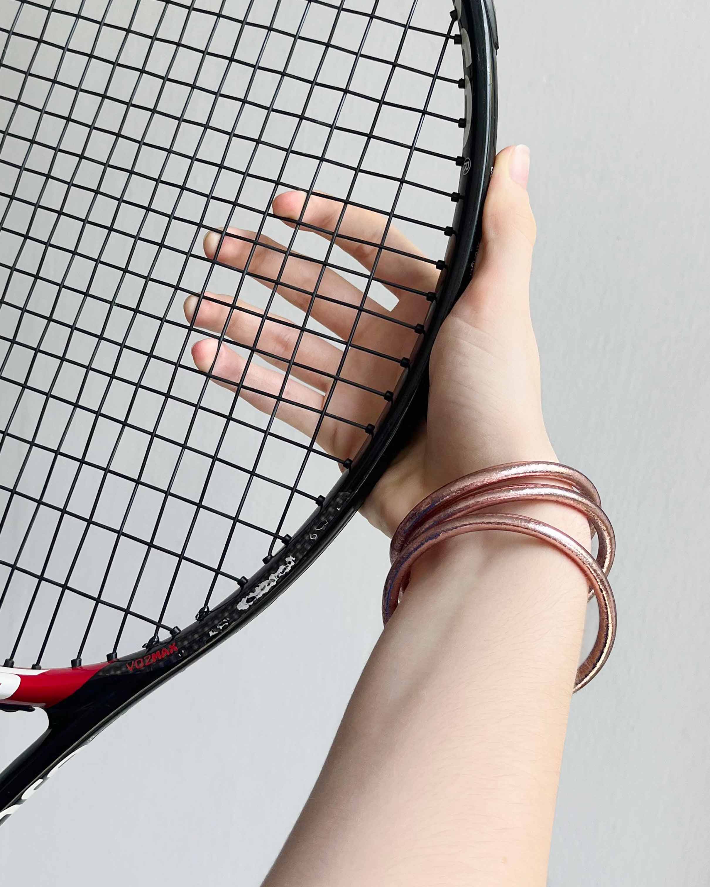 Pulseras budistas Kumlai en oro rosa, estilo grueso, llevadas mientras se juega al tenis.